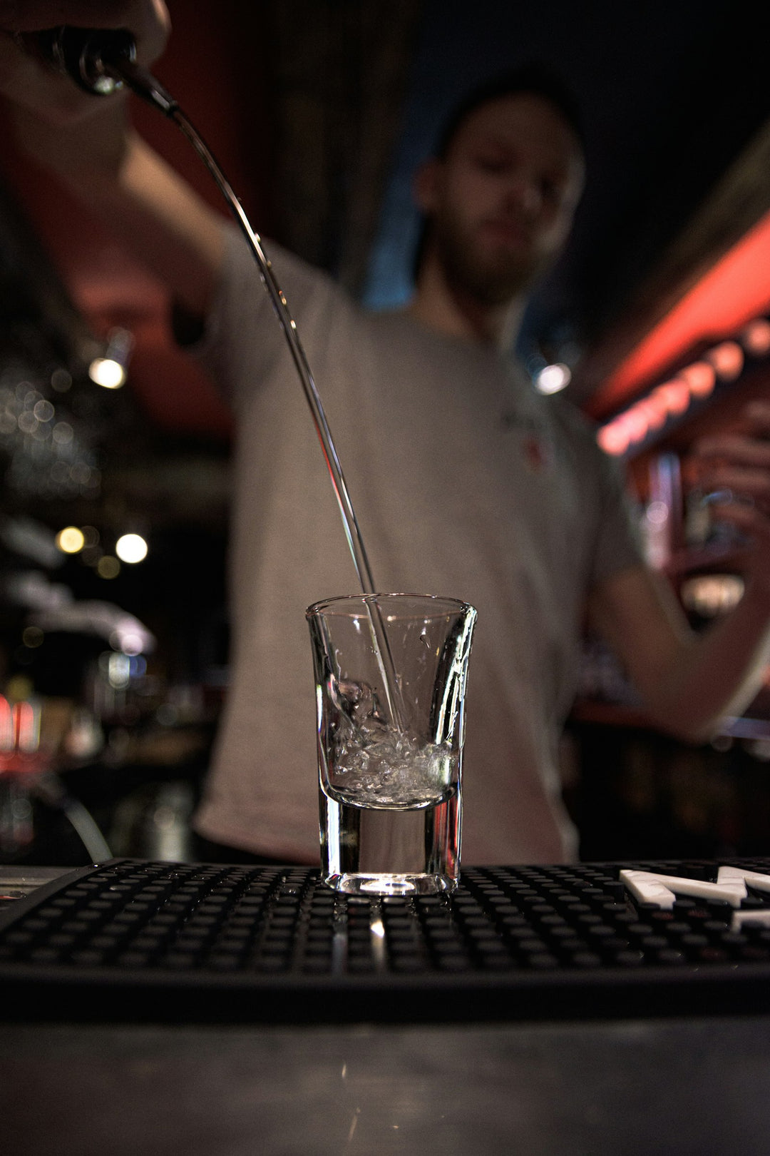 Bartender pouring vodka shot at a bar