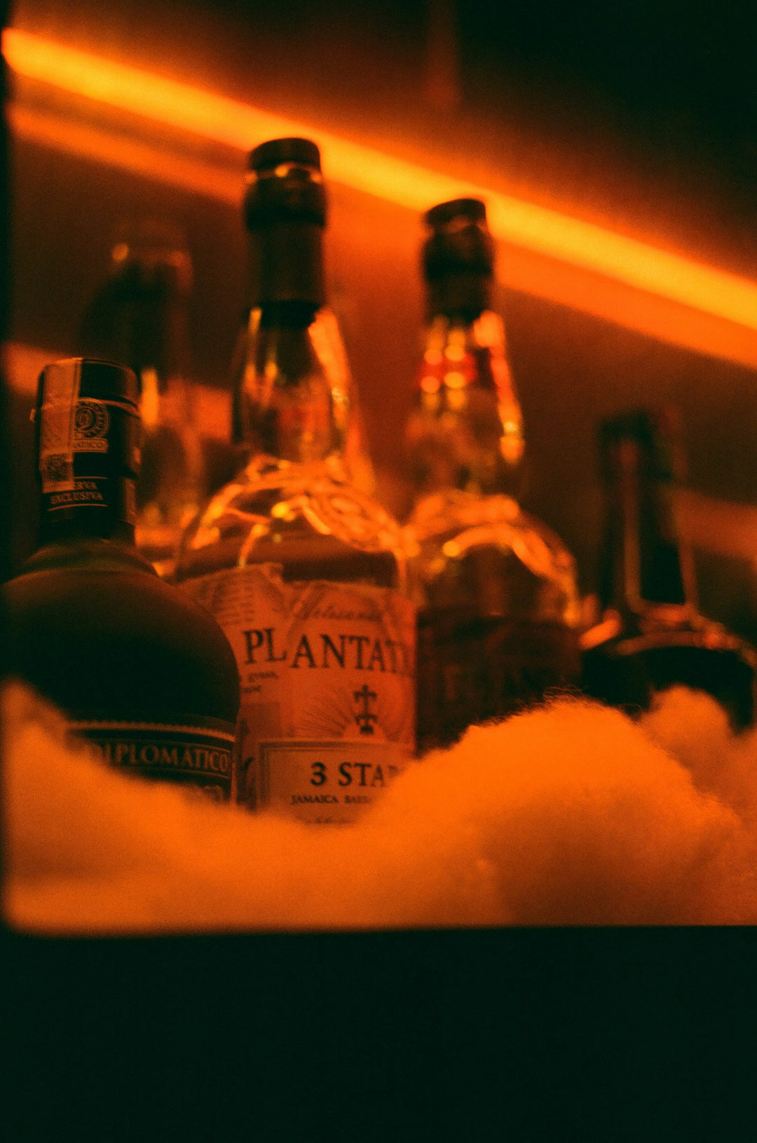 Rum bottles on ice with orange neon glow
